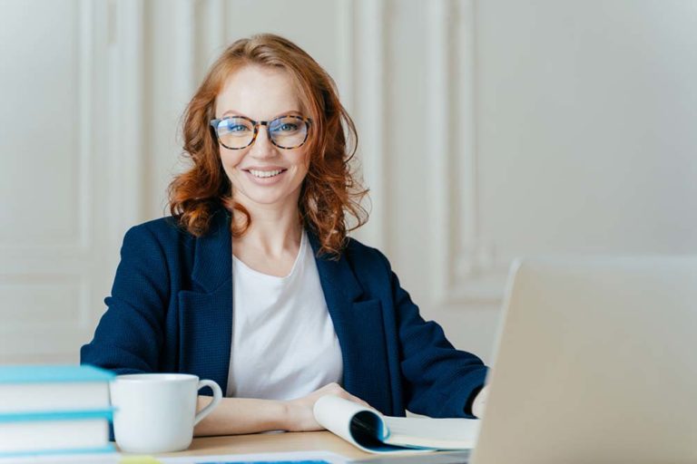 10 ways to sell more with ai redhead woman at desk